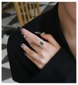 Detail van een ring met groene smaragd slijpvorm en pavé diamanten op een model - US 6 / Donkergroen