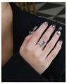 Macro-opname van een paarse amethist ring met smalandslijpsel en diamanten halo op de hand - US 6 / Paars