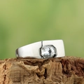 Primer plano de un anillo de metal plateado con circonita cuadrada sobre madera natural - US 7 / Plata Circón Blanco