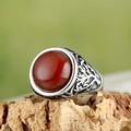 Macro detail of men's vintage ring featuring an emerald-green stone and Tree of Life carving - Steel Red Stone