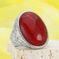 Vintage silver ring with oval red gemstone and intricate engraved patterns on yellow fabric - US 7 / Steel Wine Red