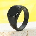 Close-up of a vintage black signet ring with a polished square stone on a stone prop - Black Black
