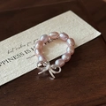 Elegant S925 silver bow and pink freshwater pearl ring on a warm wooden background - Adjustable Open / Butterfly Pearl Style (13JZ25)