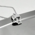 Gepolijste zilveren schedelhanger met hartvormige ogen aan een kralenketting met reflectie - Zilver