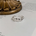 Detail eines gedrehten S925 Sterlingsilber-Rings auf einem Vintage-Buchhintergrund - Einstellbar Offen / Kleines Silber