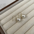Primer plano de pendientes de gancho bañados en oro de 18K con perlas blancas grandes - Plata 925 / Oro de 18K