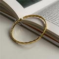 Eleganter goldener gedrehter Armreif aus S925 Sterlingsilber auf einem offenen Buch - 925er Silber / Gold (SZQ018Gold)