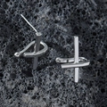 Boucles d'oreilles croix en acier poli pour hommes sur fond de roche volcanique noire - Couleur Acier