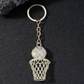 Gouden basketbalring sleutelhanger met witte kristallen op een donkere achtergrond - Goud