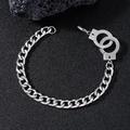 Detailansicht des Handschellen-Anhängers an einer polierten Edelstahl-Panzerarmbandkette - Silber