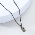 Detail eines mattschwarzen rechteckigen Anhängers mit der Glückszahl 7 an einer Kette - Schwarz