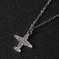 Sparkling silver airplane pendant necklace with full diamond inlay on a black leather background - Pave Rhinestone Airplane