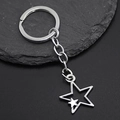 Llavero de estrella minimalista en acero inoxidable pulido sobre una base de piedra natural - Pentagrama / Plateado