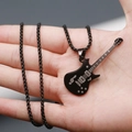 Detail van een zwarte gitaar hanger ketting met gegraveerde muzieknoten op de hand - Zwart