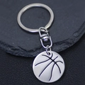 Polished basketball pendant keychain made of stainless steel on dark rock background - Silver