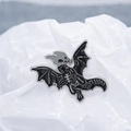 Detailed close-up of dark style flying dragon skeleton enamel pin on white background - Silver Black
