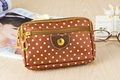 Close-up of brown polka dot canvas bag with three zippers and golden heart buckle - Coffee