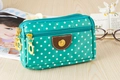 Close-up of blue polka dot canvas bag featuring three golden metal zippers and leather patch - Green