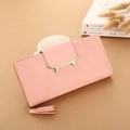 Pale pink PU leather long wallet with cat ear metal clasp and tassel detail on table - Pink
