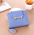 Detailed close-up of a lavender women's short wallet with cat ear clasp and tassel charm - Blue