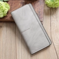 Detail of grey slim long wallet with matte texture and fine stitching on wooden surface - Gray