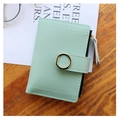 Portafoglio corto da donna verde menta in ecopelle con fibbia dorata su tavolo in legno - verde chiaro