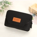 Black canvas waist bag with dual zippers and sport patch on a bright wooden surface - Black