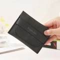 Elegant style black leather wallet held by hand in a minimalist lifestyle setting - Black