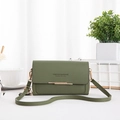 Detalle de bolso bandolera de cuero verde oscuro con hebilla dorada y logo de marca - Verde
