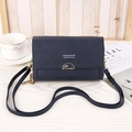 Detail of dark blue embossed leather crossbody bag with gold lock on wooden surface - Blue