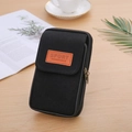 Close-up of black canvas phone belt pouch with dual zippers on a wooden table with coffee - 2-Layer Vertical Black