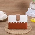 Cartera corta bicolor con diseño de líneas onduladas y cierre de cremallera metálica - café
