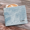 Slim men's denim fabric wallet with bifold design and metal logo on a wooden surface - Blue