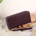 Detail of deep purple long wallet with floral embossing and double zipper feature - Purple