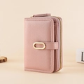 Detail view of pink lychee textured leather wallet with card slots and golden ring buckle - Pink