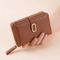 Detailed texture of brown litchi grain leather wallet with gold metal ring buckle - Coffee