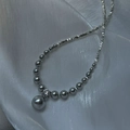 Detalle de collar de perlas grises con colgante de circón sobre fondo de seda plata - Plata 925 / Gris Plata