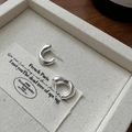 Pendientes de aro en C mate de plata de ley S925 sobre un expositor de joyas beige - Plata 925 / Plateado