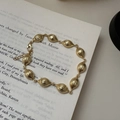 Bracciale in argento S925 dorato con perline scanalate a oliva su pagine di libri - Stile a Grani d'Oliva Striati (SLS051) / Argento 925 / Oro