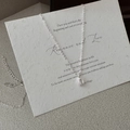 Dettaglio macro della collana a ferro di cavallo in argento S925 con texture opaca su carta - Argento 925 / Argento