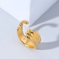 Macro shot of polished gold skull hand hug ring showcasing intricate joint textures - Adjustable Open / Gold