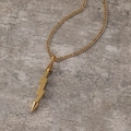 Detail eines goldenen Blitz- und Pfeilanhängers an einer feinen Kette mit Glanz - Gold