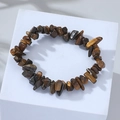 Detalle de una pulsera de ojo de tigre con cuentas pulidas irregulares en base blanca - Ojo de Tigre Amarillo
