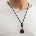Pendentif hexagramme en œil de tigre sur collier en corde noire porté par un mannequin - Marron