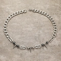 Punk-Gothic-Halskette mit silbernen Spikes und dunkelgrauen Perlen auf Steinoberfläche - Silber
