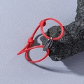 Bracelet corde tressée rouge minimaliste avec boucle en métal poli sur roche volcanique - Rouge
