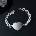 Bracciale con ciondolo a cuore in argento lucido a catena grossa su sfondo di pietra - Bracciale a Cuore
