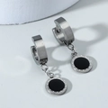 Détail macro de boucles d'oreilles carrées vintage avec fini argent brossé et incrustation noire - Rond