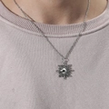 Dettaglio della collana con pendente a sole in argento vintage su una maglietta - Sole Argento