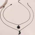 Double-layered black celestial necklace featuring sun and moon pendants on a beige background - Black Set